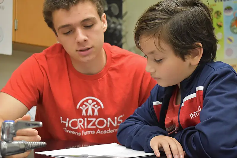 Andre helping student one or one with paperwork