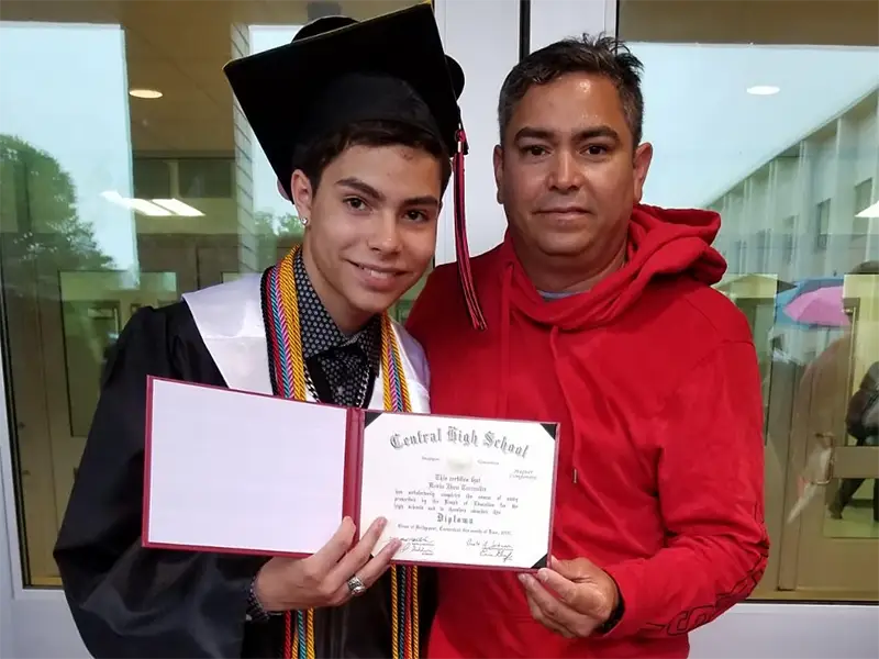 Kevin with father and high school diploma